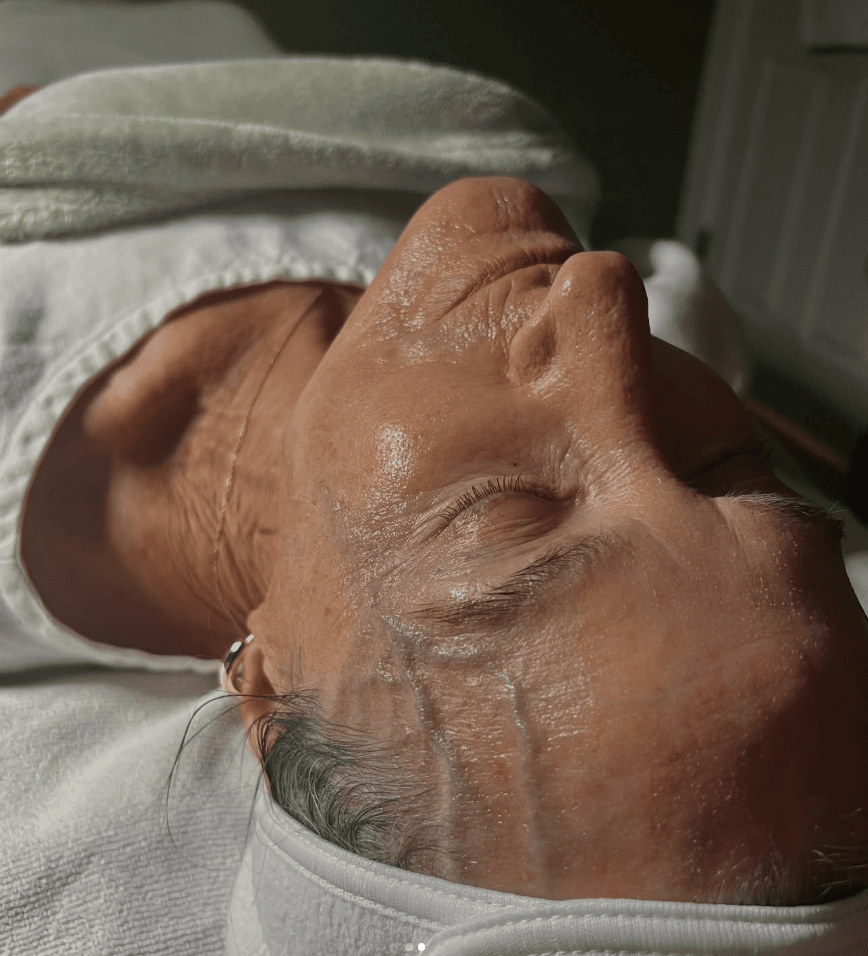 Client relaxing prior to receiving a professional-grade hydrating sheet mask facial at Pavona Parlor, a skincare studio in Beaufort SC